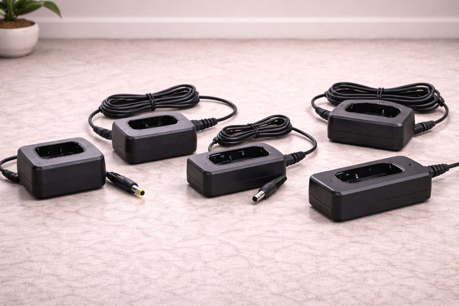 Assorted cordless vacuum replacement chargers arranged on a table